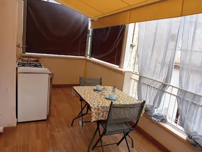 a table and chairs in a room with two large windows at Casa Fugardi in Castellammare del Golfo