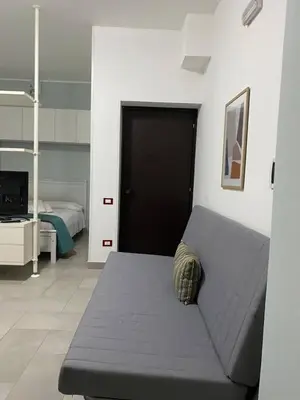 a living room with a couch and a bedroom at Casa Fugardi in Castellammare del Golfo