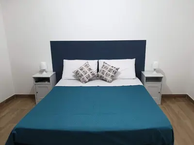 a blue and white bed with two pillows on it at Casa Fugardi in Castellammare del Golfo