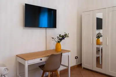 a couch against a white wall with pictures on the wall at Palermo e Dintorni - Valentino Apartment in Palermo