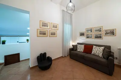 a living room with a couch and pictures on the wall at Palermo e Dintorni - Valentino Apartment in Palermo