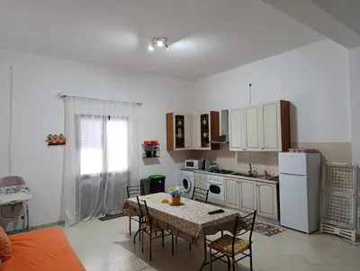 a kitchen with a table and chairs and a kitchen with white appliances at casa colombo in Balestrate