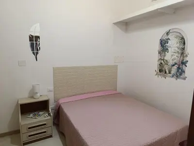 a small bedroom with a bed and a night stand at casa colombo in Balestrate