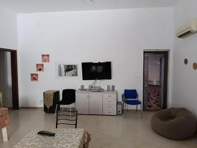 a living room with two chairs and a tv at casa colombo in Balestrate