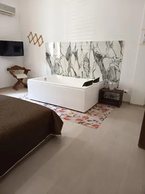 a white bath tub in a room with a bed at casa colombo in Balestrate