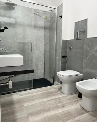 a bathroom with a toilet and a sink and a shower at BIBI rooms and suite in Palermo