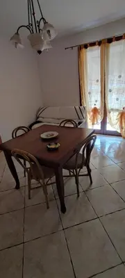 a dining room with a wooden table and chairs at Appartamento Arancio in San Vito lo Capo