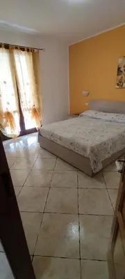 a bedroom with a bed and a tiled floor at Appartamento Arancio in San Vito lo Capo