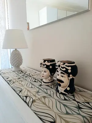 two masks sitting on a bed next to a lamp at Stella del Centro Apartment in Palermo