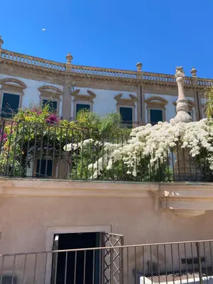 a building with a balcony with white flowers on it at Calvello studio apartment in Palermo