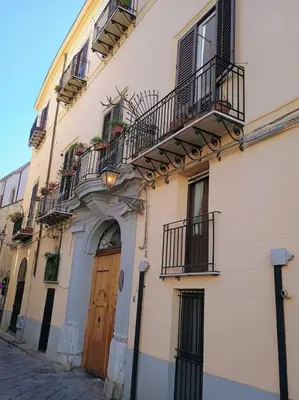 a building with a wooden door and balconies on it at Calvello studio apartment in Palermo