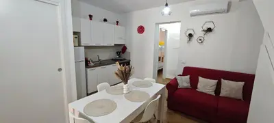 a living room with a red couch and a table at Profumo di casa in Lascari