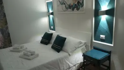 a bedroom with a white bed with pillows and a mirror at Profumo di casa in Lascari