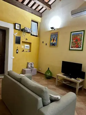 a living room with a couch and a tv at Carmine House in Monreale