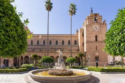 a fountain in front of a building with a clock tower at Carmine House in Monreale