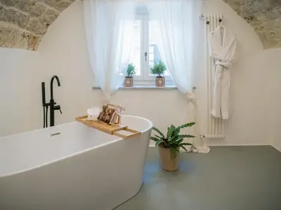 a white bathroom with a tub and a window at Palazzo Santa Ninfa - Luxury Mansion in Palermo