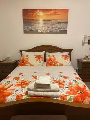a bedroom with a bed with orange flowers on it at Villa Rosa Bella Vista Balestrate in Balestrate