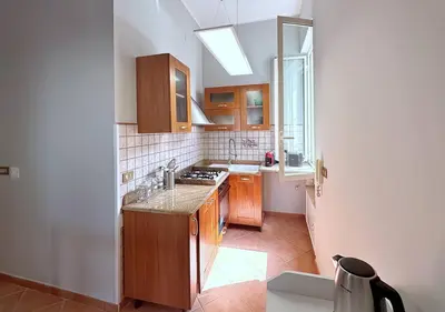 a kitchen with wooden cabinets and a sink and a window at Solemar Sicilia - Casa Scordia in Palermo