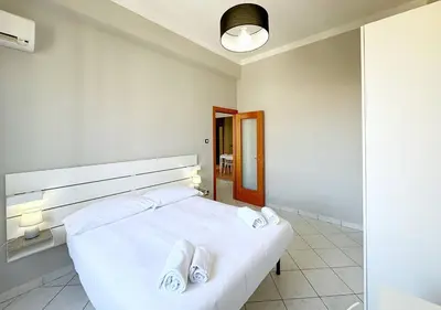 a bedroom with a white bed with white towels on it at Solemar Sicilia - Casa Scordia in Palermo