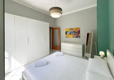 a white bedroom with a large white bed and a mirror at Solemar Sicilia - Casa Scordia in Palermo