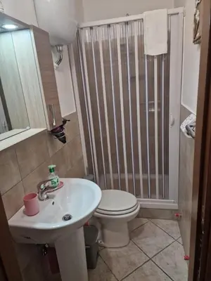 a bathroom with a toilet and a sink and a shower at Le stanze di Aurora in Palermo
