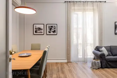 a dining room with a table and a chair at Constance Luxury Apartment by DomuSicily in Palermo