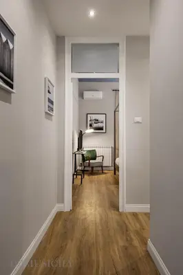 a hallway with a door leading into a living room at Constance Luxury Apartment by DomuSicily in Palermo
