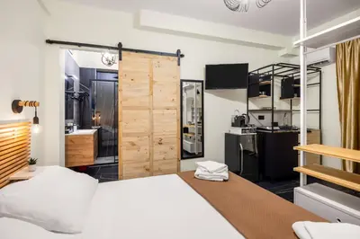 a bedroom with a large bed and a kitchen at Al Borghetto marinaro in Palermo
