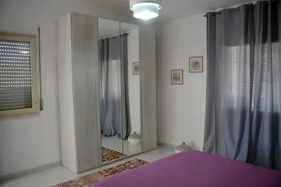 a bedroom with a large mirror in front of a shower at Villino Anna e Pippino in Calatafimi
