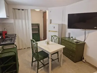 a kitchen with a table and chairs and a kitchen with a refrigerator at Gianni House Palermo in Palermo