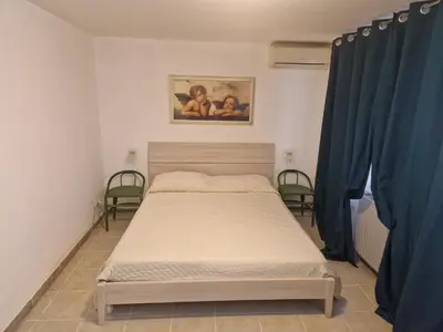 a bed in a room with two chairs and a painting at Gianni House Palermo in Palermo