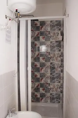 a bathroom with a shower with a toilet and a sink at Leone Guest House in Palermo