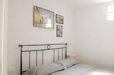 a bed in a bedroom with three pictures on the wall at Leone Guest House in Palermo
