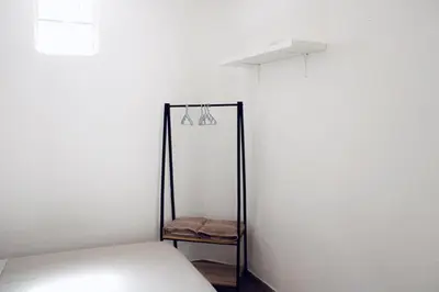a room with a bed and a white wall at Leone Guest House in Palermo