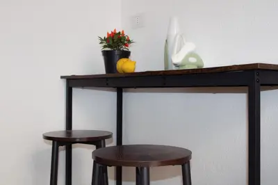a wooden table with two stools under it with a shelf at Leone Guest House in Palermo