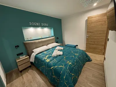 a bedroom with a bed with a green comforter at Sogni d'oro in Partinico