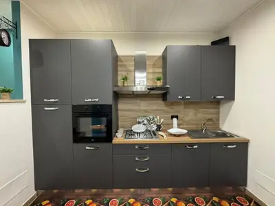 a kitchen with black cabinets and a sink and a stove at Sogni d'oro in Partinico