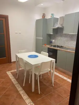 a white table and chairs in a kitchen at Vittorosa House in Palermo