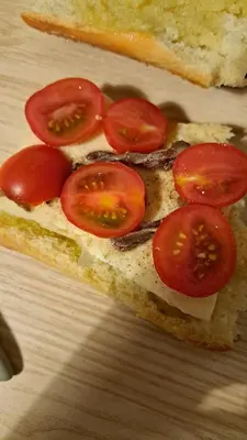 a sandwich with tomatoes on it on a table at Villa Alba in Mandra Capreria