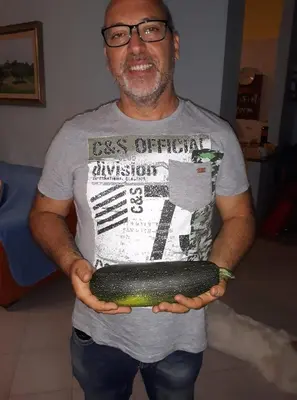 a man holding a large cucumber in his hands at Villa Alba in Mandra Capreria