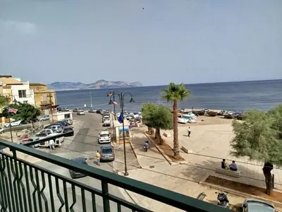 a view of a street with a parking lot and the ocean at Casa vacanze anto antonella in Bagheria