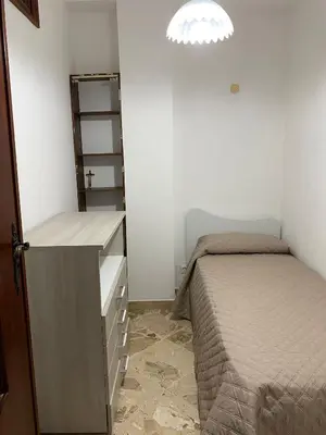 a small bedroom with a bed and a dresser and a light at Casa vacanze anto antonella in Bagheria