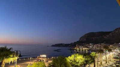 a view of a city and the water at night at Casa vacanze anto antonella in Bagheria