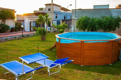 two chairs and a hot tub in a yard at Casa Vacanze Caruso in Carini