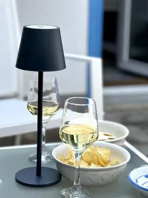 two glasses of white wine and a lamp on a table at Residenza Saturno 7 in Palermo
