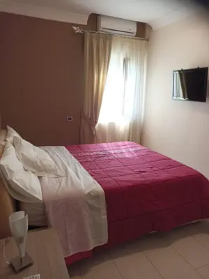 a bedroom with a bed with a red blanket and a window at Casa delle Stelle in Mondello