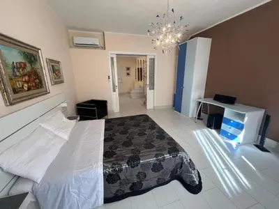 a bedroom with a large bed and a chandelier at Casa delle Stelle in Mondello