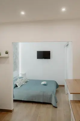 a bedroom with a bed in a white room at Barù home in centro in Palermo