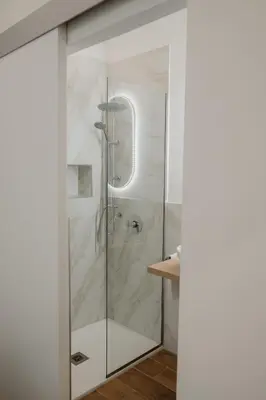 a shower with a glass door in a bathroom at Barù home in centro in Palermo