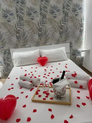 a bed with hearts on it with a tray of wine glasses at Barù home in centro in Palermo
